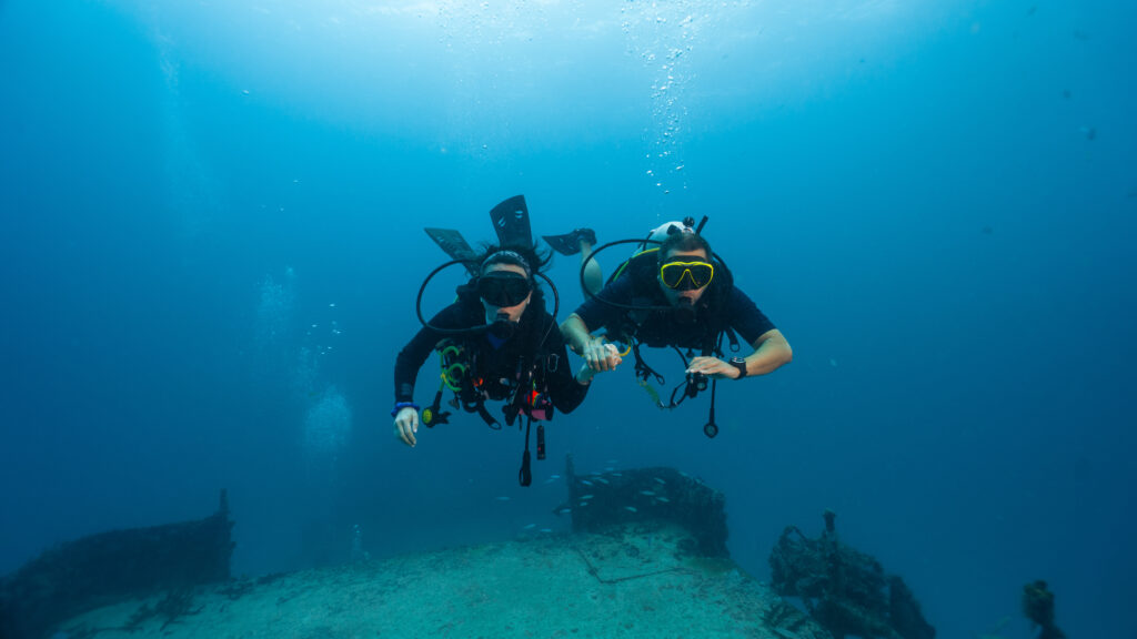 scuba divers near deep shipwreck